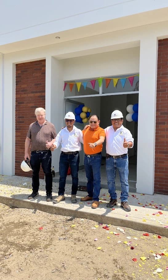 Edificio terminado con cliente recibiendo las llaves frente a la fachada