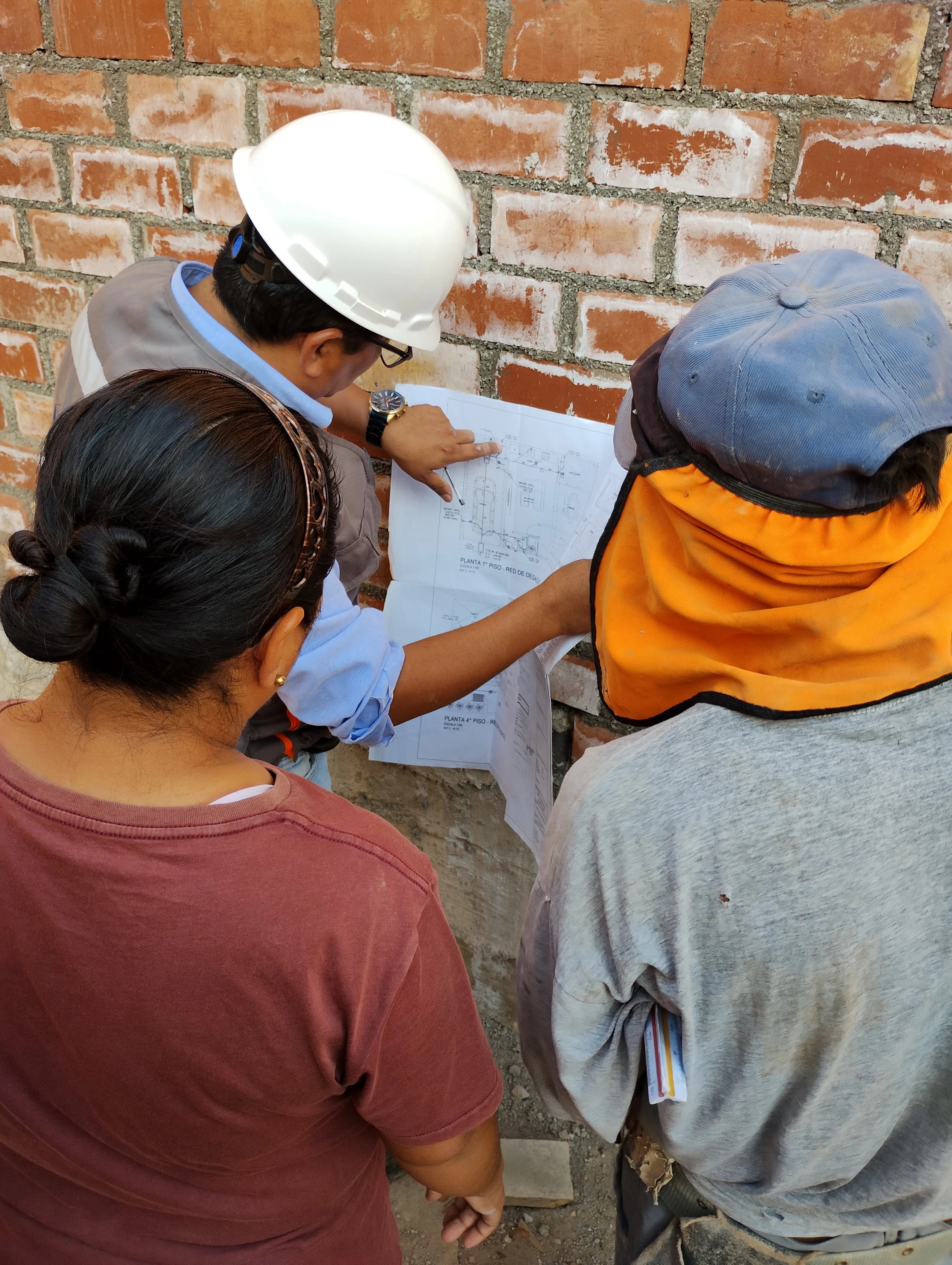Propietarios y equipo de VL Arquitectos revisando los planos del proyecto en una visita técnica